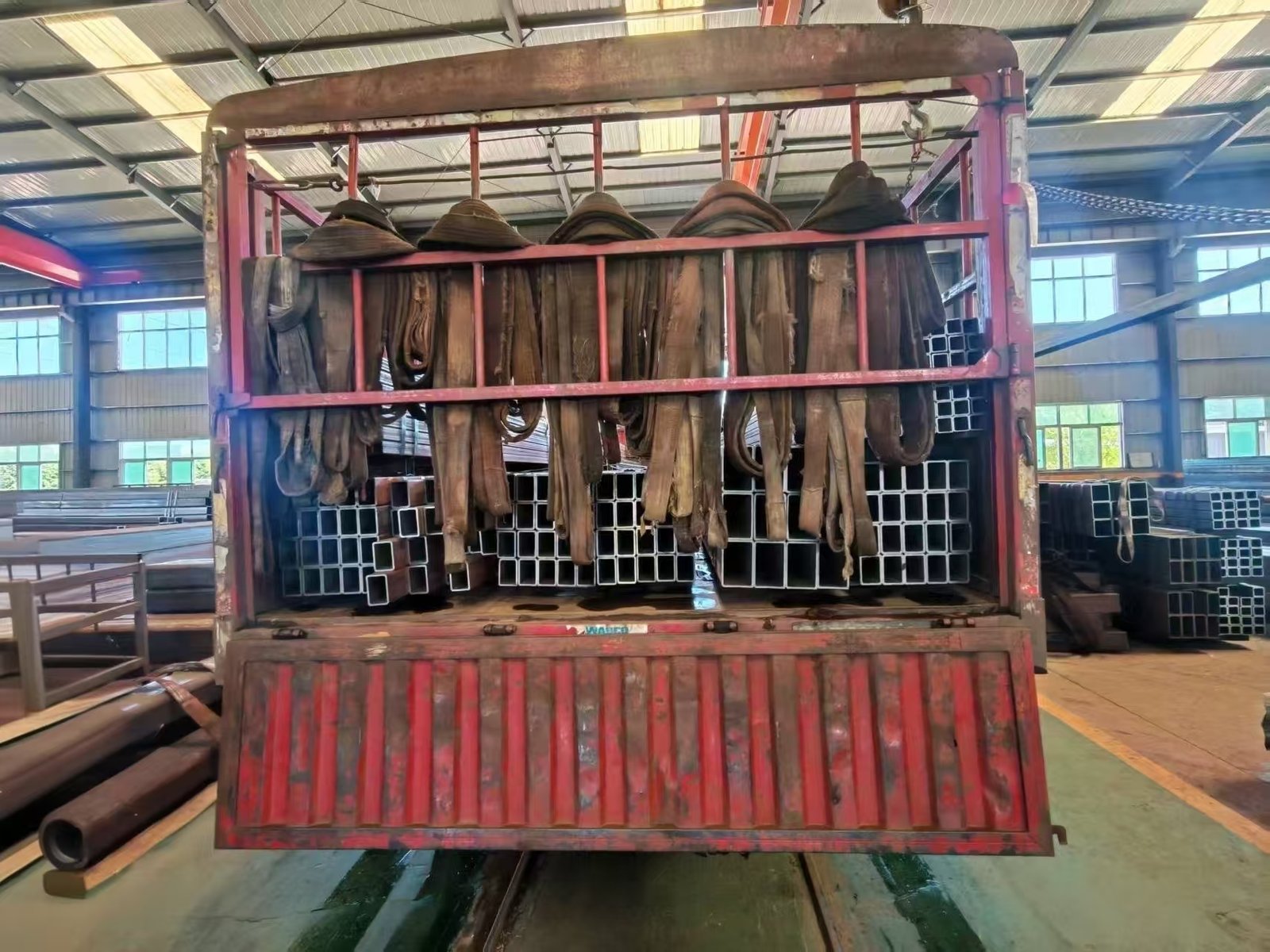Steel tube bundles being loaded into an export container at the SD XJY Steel factory yard.