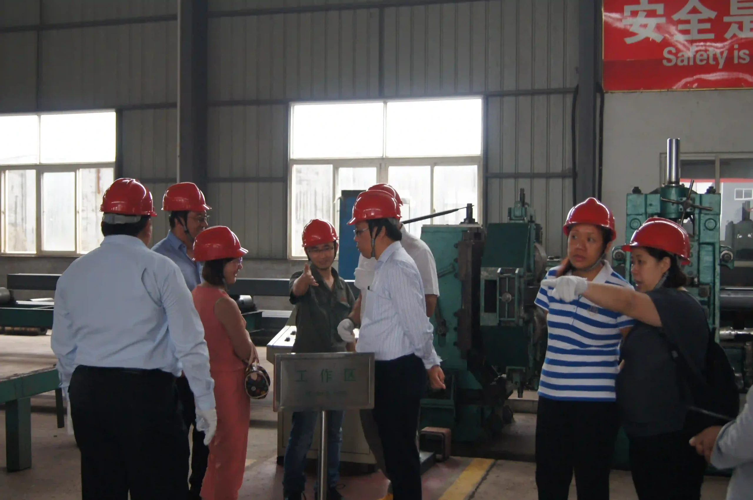 International customers walking through the steel pipe production line during a plant visit.