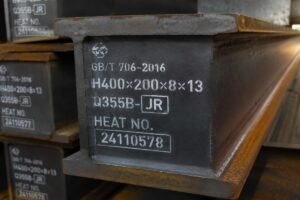 Close-up view of steel beam end markings showing grade suffix JR and heat number for traceability