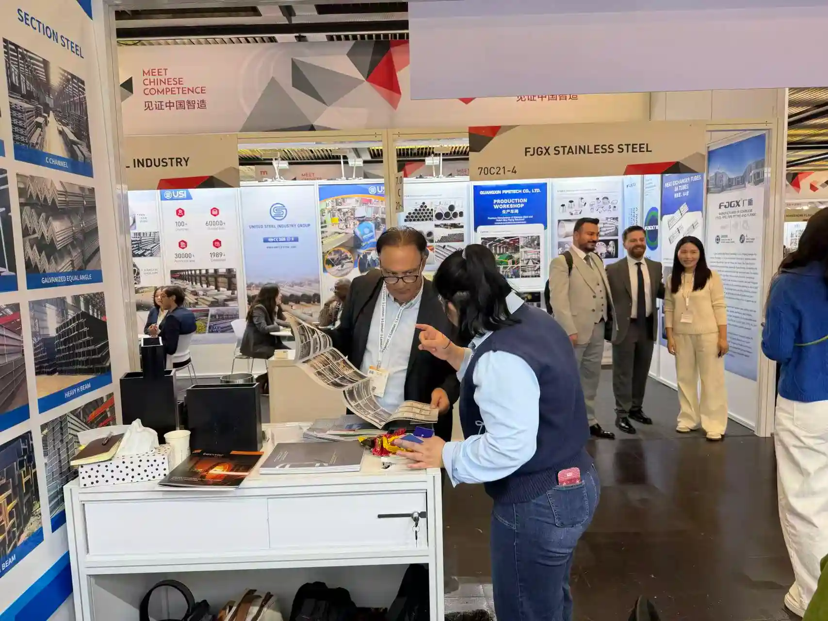 Visitors collecting product catalogues at the SD XJY Steel exhibition stand.